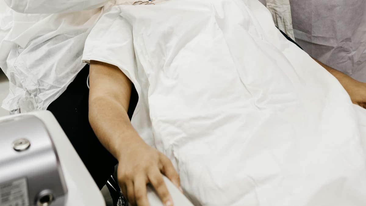 Équipe dentaire réalisant un soin au fauteuil, aspiration en cours