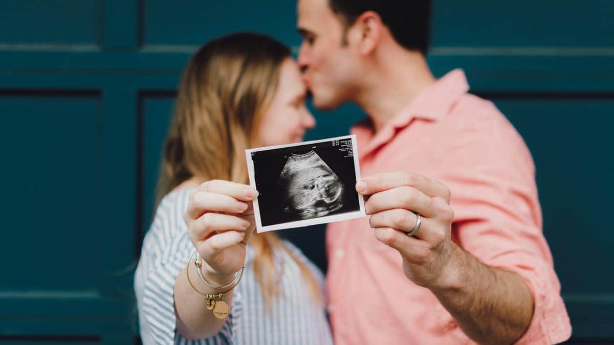 Couple regardant une échographie, parcours de procréation médicalement assistée