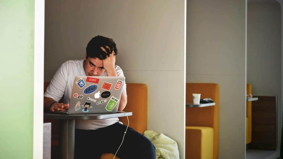 Personne épuisée, tête dans la main, devant son ordinateur